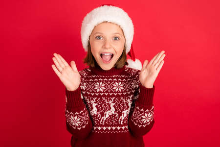 Photo of little girl happy positive smile amazed shockede surpriseed holiday sale isolated over red color backgroundの写真素材