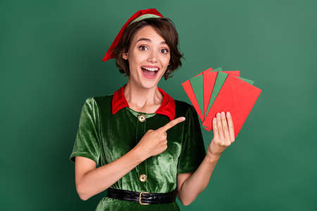 Portrait of attractive cheerful girl holding demonstrating letters eve day time isolated over green color backgroundの写真素材