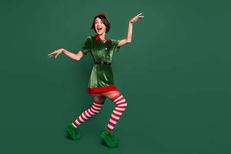 Full length body size view of attractive cheerful funny girl dancing having fun isolated over green color backgroundの写真素材