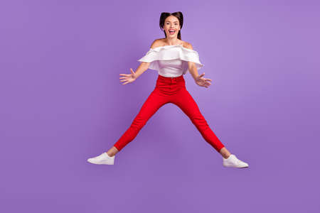 Photo of positive energetic lady jump hold hands empty space wear white blouse isolated violet color...