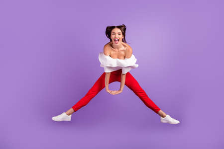 Photo of crazy careless lady jump hold hands scream wear white blouse trousers sneakers isolated violet color backgroundの写真素材