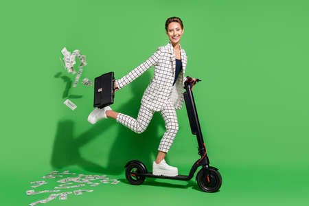 Photo of pretty cute young lady wear plaid outfit smiling driving eco transport money flying...