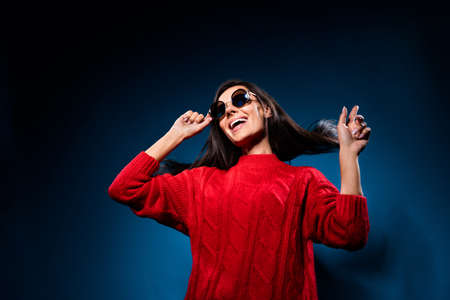 Low angle view photo of young woman happy positive smile dance club music isolated over dark blue color backgroundの写真素材