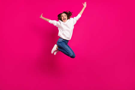 Full size photo of young cheerful girl happy positive smile jumper active sporty isolated over pink color backgroundの写真素材
