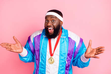 Photo of young african man happy positive smile champion sportsman win gold medal isolated over pink color backgroundの写真素材