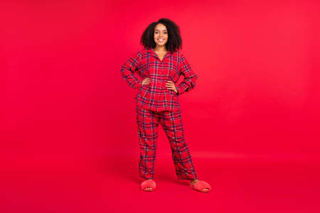 Full size photo of joyful happy afro american woman hands waist body positive cool xmas isolated on red color backgroundの写真素材