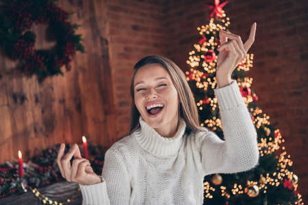 Photo portrait smiling woman wearing knitted sweater smiling laughing overjoyed dancing on new year partyの写真素材
