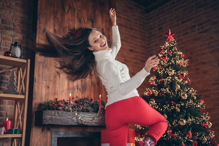 Photo of charming shiny young lady wear white pullover smiling dancing indoors house home roomの写真素材
