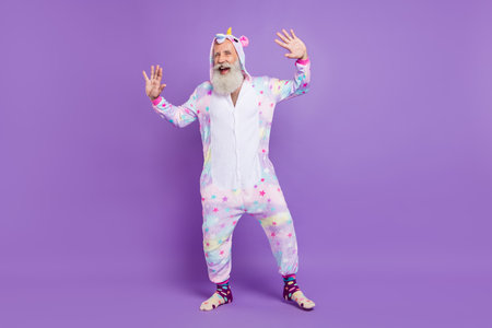 Full length photo of old happy funny funky man wear pajama good mood enjoy isolated on purple color backgroundの写真素材