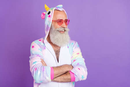 Portrait of attractive cheery content man wearing pajama folded arms copy space isolated over violet...