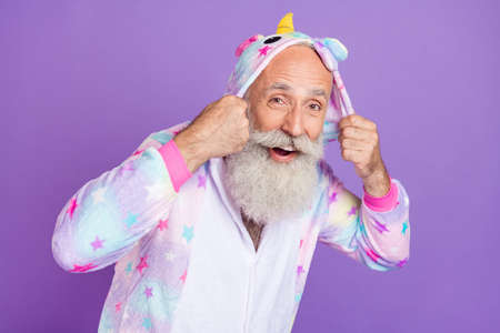 Full size photo of happy positive old man wear nightwear hands hood smile isolated on purple color backgroundの写真素材
