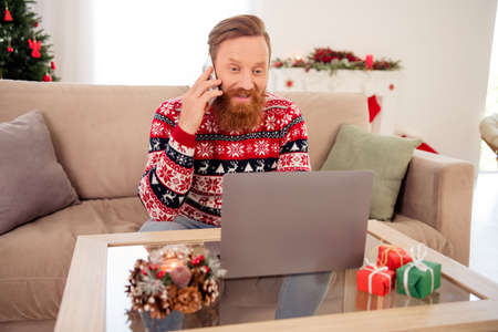 Photo of good mood businessman work remote in laptop at home house talking on phone communicating with colleagueの写真素材