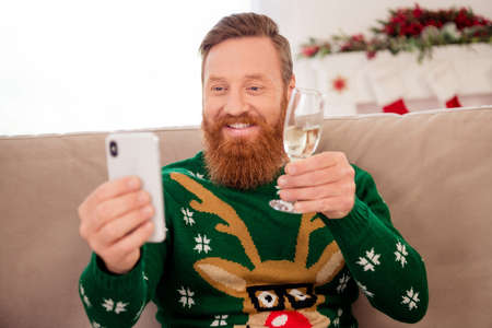 Photo of positive good mood attractive male take selfie on phone hold glass of champagne toast cheers celebrate new yearの写真素材