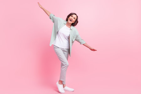 Full size photo of positive excited aged person arms flying have good mood isolated on pink color backgroundの写真素材