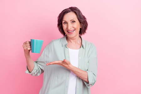 Photo of satisfied pretty aged person arm palm show fresh cacao have good mood isolated on pink color backgroundの写真素材