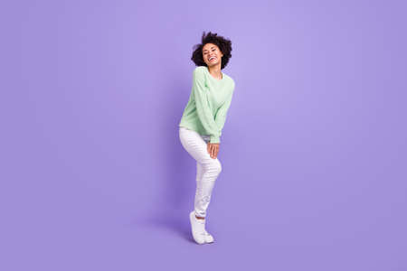 Full body photo of cheerful dark skin charming woman good mood wear casual clothes isolated on purple color backgroundの写真素材