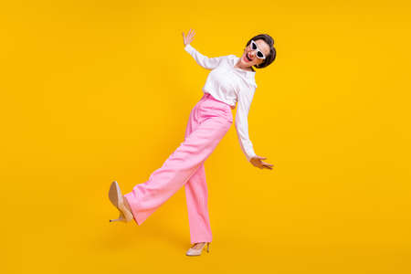 Full length profile side photo of aged excited woman happy positive smile go walk step isolated over yellow color backgroundの写真素材