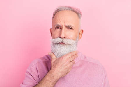 Photo of strict grey hair senior man hand chin wear pink sweater isolated on pastel color backgroundの写真素材