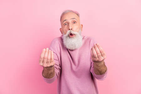 Photo of angry grey hair mature man ask money wear pink sweater isolated on pastel color backgroundの写真素材