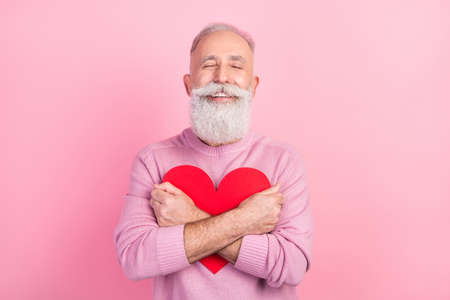 Photo of kind grey beard senior man hug heart wear pink sweater isolated on pastel backgroundの写真素材