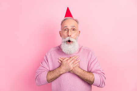 Photo of sweet shocked age gentleman wear sweater spectacles headwear arms chest open mouth isolated pink color backgroundの写真素材