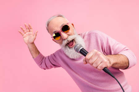 Photo of funky grey hair elder man sing wear eyewear sweater isolated on pink color backgroundの写真素材
