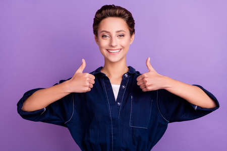 Photo of funny young short hairdo lady thumb up wear jeans overall isolated on violet color...