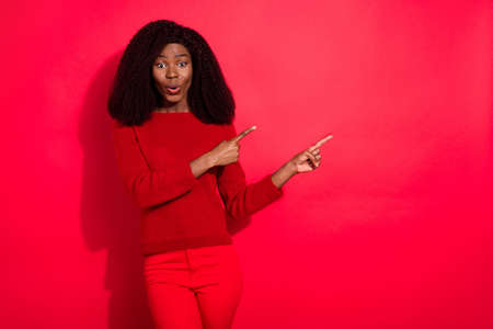 Portrait of attractive amazed girl demonstrating copy space ad advert pout lips isolated over bright red color backgroundの写真素材