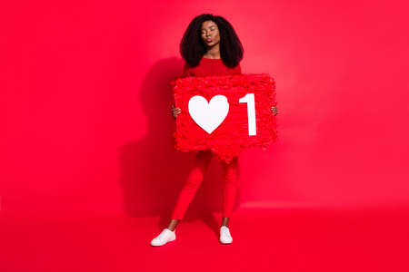 Full size photo of young black girl pouted lips send air kiss hear like reaction popular isolated over red color backgroundの写真素材