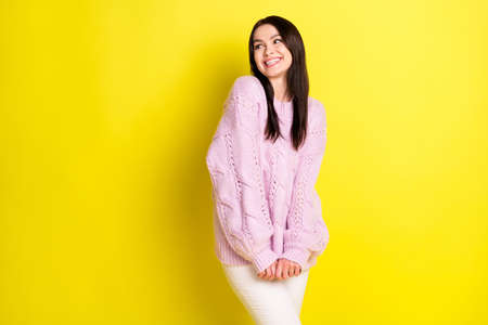 Photo of teen shy brown hairdo lady look empty space wear pink pullover isolated on vivid yellow color backgroundの写真素材
