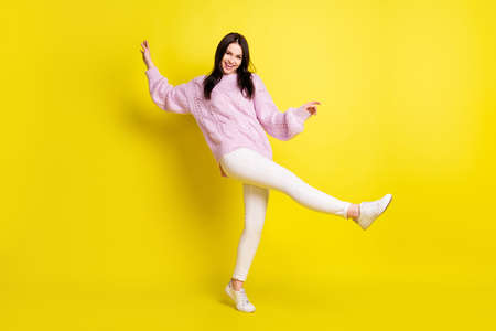 Full size photo of teen brown hairdo lady dance wear pink sweater pants isolated on vivid yellow...