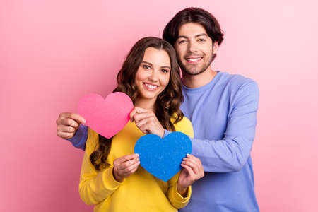 Photo of young couple happy positive smile hug hold small card heart romantic isolated over pink color backgroundの写真素材