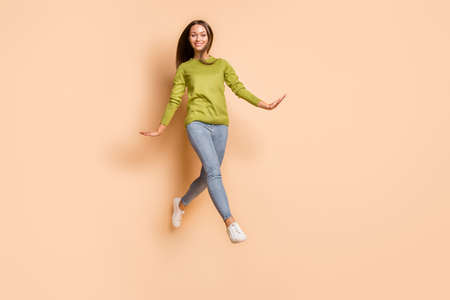 Full length body size view of pretty funny cheerful girl jumping strolling having fun isolated over...