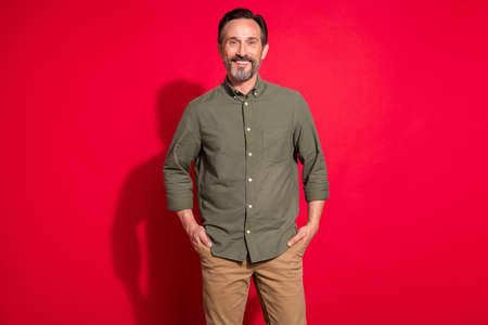 Photo portrait man wearing casual clothes smiling confident isolated vivid red color backgroundの写真素材