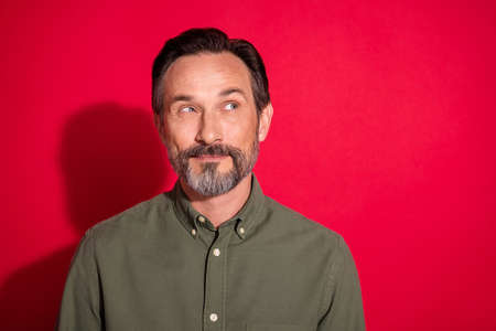 Photo portrait businessman wearing green shirt smiling looking copyspace isolated bright red color backgroundの写真素材