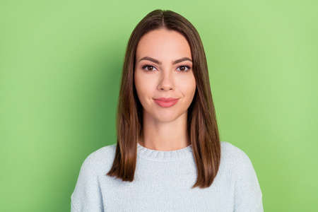 Photo of cute millennial brunette lady wear blue sweater isolated on green color backgroundの写真素材