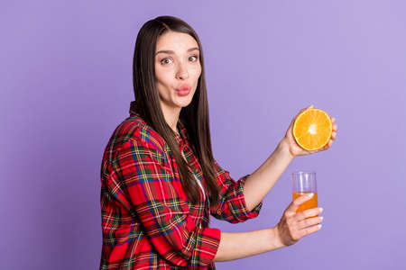 Profile photo of pretty brunette hairdo millennial lady do oranges juice wear red shirt isolated on purple color backgroundの写真素材