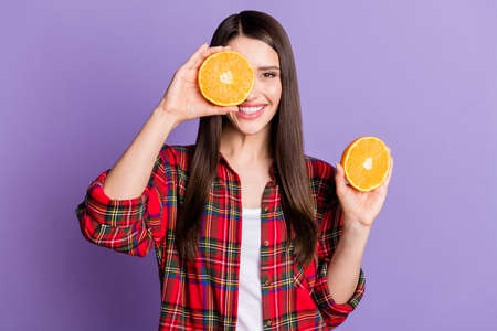 Photo of joyful brunette hairdo millennial lady hold oranges wear red shirt isolated on purple color backgroundの写真素材