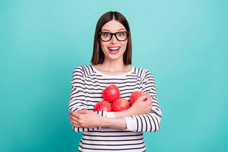 Photo of amazed lady hold bunch apple excited mood wear eyeglasses striped shirt isolated on turquoise color backgroundの写真素材