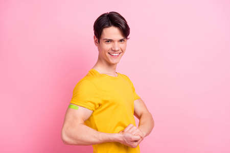 Photo of sweet strong young man wear yellow t-shirt dark eyewear smiling vaccination done isolated pink color backgroundの写真素材