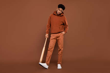 Full body photo of anger short hairdo young guy hold bit dress sportswear trousers sneakers isolated on brown backgroundの写真素材