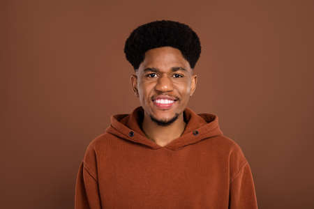 Photo of optimistic brunet hairdo young guy dress sportswear isolated on brown color backgroundの写真素材