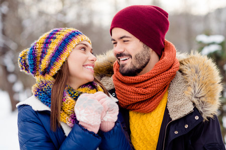 Photo portrait of lovely couple embracing smiling in snowy forest in winterの写真素材