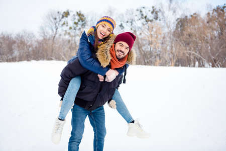 Portrait of cheerful glad man hold on back positive adorable girl toothy smile look camera have good mood outdoorsの写真素材