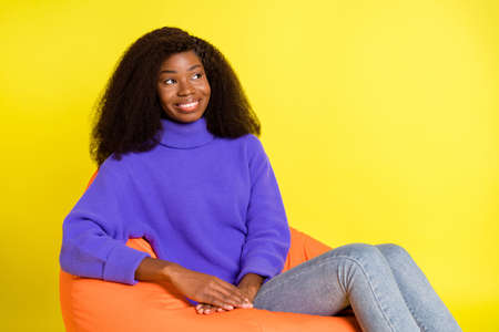 Profile portrait of pretty cheerful dark skin person look empty space imagine isolated on yellow color backgroundの写真素材