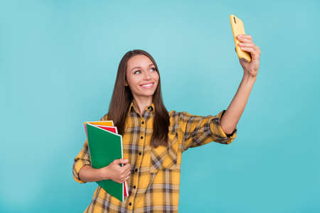 Portrait of charming positive lady make selfie hold copybook good mood isolated on blue color...
