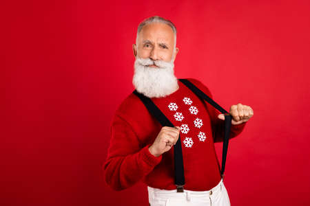 Photo of aged man have fun pull suspenders christmas time noel holiday isolated over red color backgroundの写真素材