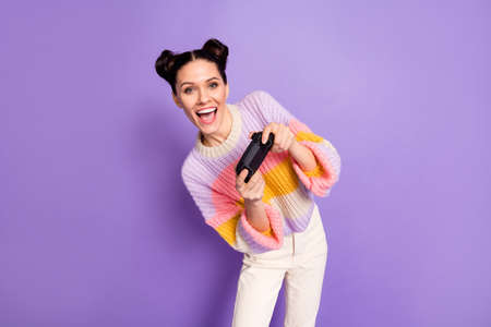 Portrait of lovely cheerful girl playing game celebrating having fun contest isolated on bright violet purple color backgroundの写真素材