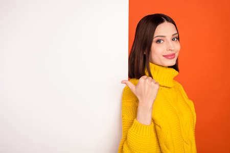 Profile side photo of young woman happy positive smile point thumb empty space ad choise selcet isolated over orange color backgroundの写真素材
