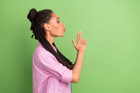 Photo of sweet confident dark skin lady wear pink shirt blow fume handgun empty space isolated green...